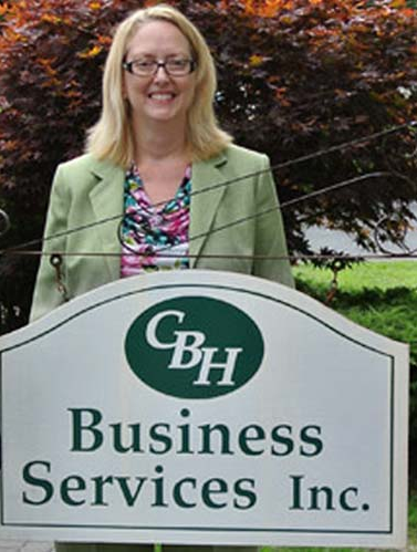 Catherine Bostock-Hudy in front of company sign